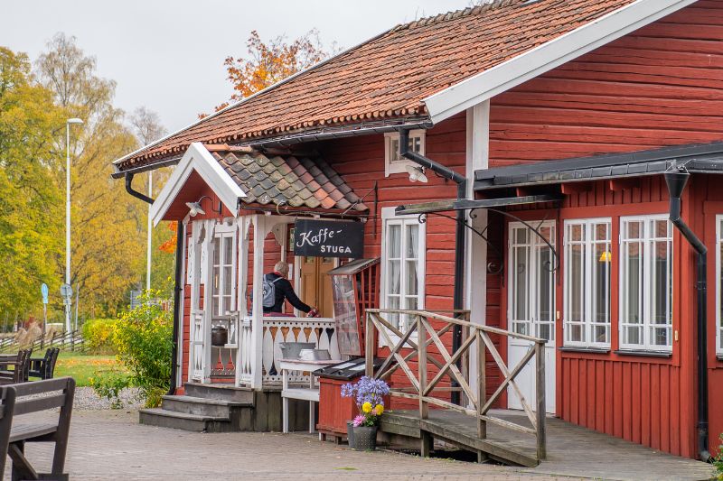 En charmig kaffestuga i traditionell bruksmiljö, där besökare kan slå sig ner och njuta av en fikastund.