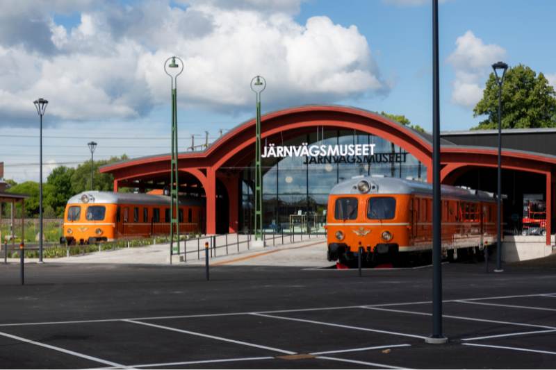 Entre till järnvägsmuseum i Gävle. Två orangea tåg står vid ingången.